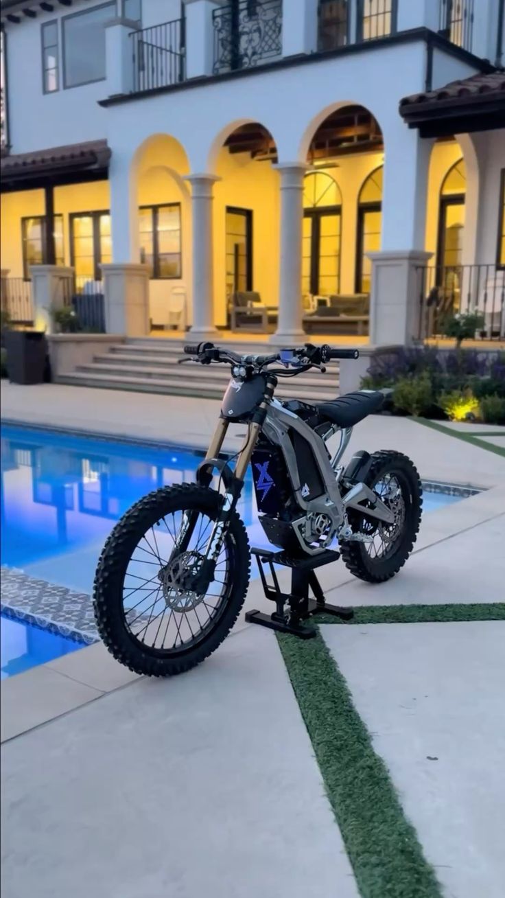 Custom Sur-Ron in front of villa at dusk